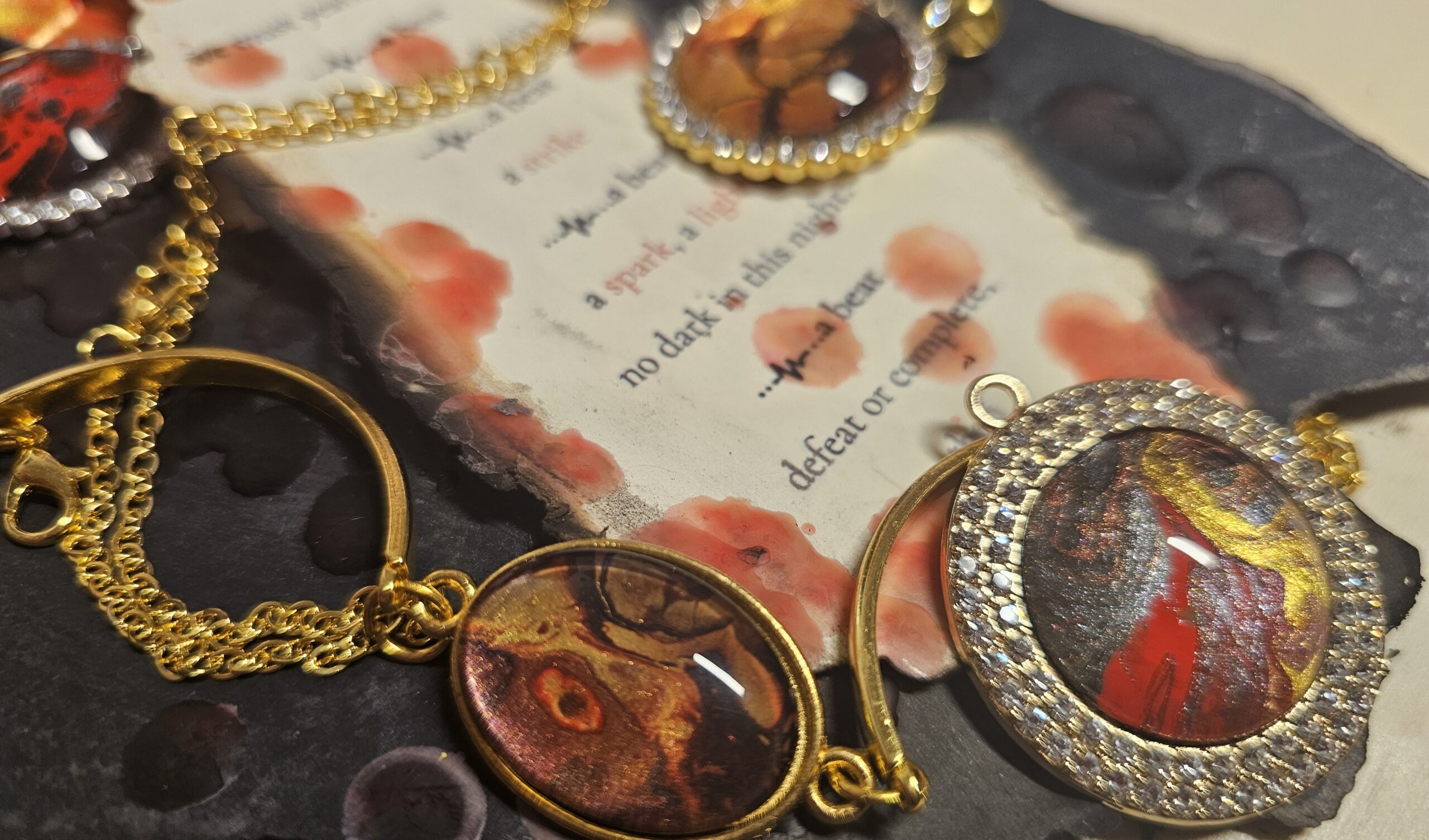 Firescapes wearable art pendants with gold and red tones